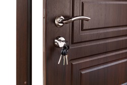 Open door handle. Door lock with keys. Brown wooden door closeup isolated. Modern interior design, door handle. New house concept. Real estate.