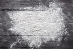 Baking class or recipe concept on dark background, sprinkled wheat flour with free text copy space. Baking preparation, top view on wooden board or table. Cooking dough or pastry.