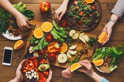 Healthy food dinner table. Women at home together, eating fruits and vegetables, top view, flat lay, crop