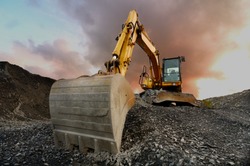 Image of a wheeled excavator on a quarry tip