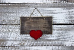 Blank wood sign with large red heart hanging on antique rustic white wooden background; Valentines Day, family and love concept background with copy space
