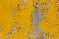 Texture of old weathered rough peeling golden oil paint on a concrete wall. Background for creative vintage design. Cracked old paint on the wall