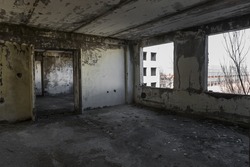 Interior of abandoned administrative building. Interior ruins of industrial factory. An old concrete staircase, ruins, corridor with garbage and mud, ruined walls of  unfinished office business center