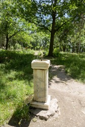 City fountain for drinking water on an old marble column in city park. city bowl for drinking people. Water flows from tap, fountain to drink water by people in park