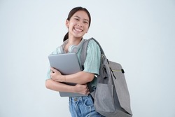 Young Asian student girl holding laptop and backpack on isolated background