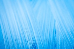 Extreme close up of blue acrylic paint texture showing brush strokes. Selective focus.
