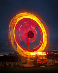 Long exposure of a fairground ride causing light trails