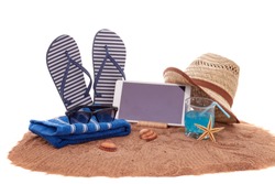 Beach accessories, glass of cool cocktail and computer tablet, lying on the sand on white background. Concept of sea vacation and travel. Summer background, Travel agency. Internet shop