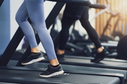 Legs of two girl friends working out on treadmill