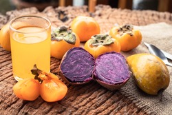sweet potato, persimmon and orange juice on wooden background