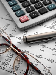 calculator, pen and glasses on financial statement
