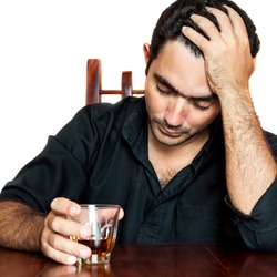 Portrait of an hispanic man holding an alcoholic drink suffering a headache (isolated on white)