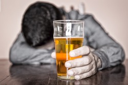 Black and white image of a sleeping drunk man (only his beer is in color)