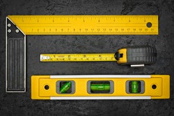 Set of measuring tools on a textured black metallic background