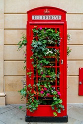 A former public red telephone booth filled with plants in the City of Bath in Somerset, UK