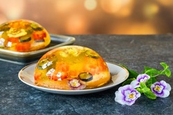 Lemon jelly globes with fresh fruit, edible flowers and gold flakes on pistachio biscuit - gourmet dessert