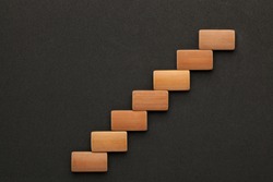 Seven wooden blocks in the shape of a staircase. Business concept.