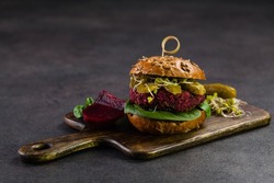 Vege burgers with carrots, beetroots and mushrooms. Front view. Black background.