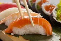 The composition of nigiri sushi with tuna, salmon, shrimp, butterfish on rice 
