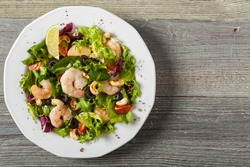 Shrimp salad with tomato, olives and cashew nuts. Top view