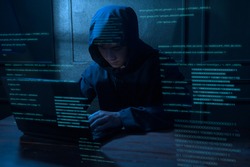 A Hacker is using laptop computer to steal data in the night 