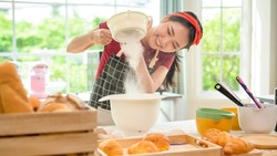 A young beautiful Asian woman is baking in her kitchen  , bakery and coffee shop business 