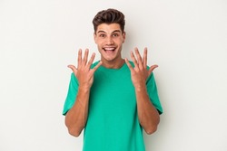 Young caucasian man isolated on white background showing number ten with hands.