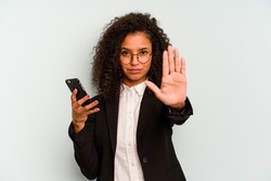 Young business Brazilian woman holding mobile phone isolated on white background standing with outstretched hand showing stop sign, preventing you.