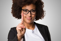 business black woman doing number one gesture on a grey background