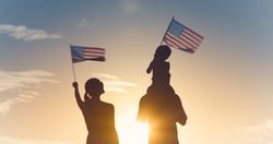 Patriotic silhouette of family waving American USA flags. 