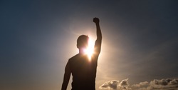 People, strength, power, and never giving up concept. Strong man with fist up to the sky. 