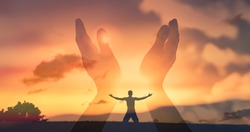 Worshiping hands raised up with open palms to the sunset sky.  Christian Religion concept background. Faith, hope, and prayer concept. 