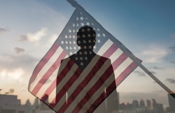 Stand strong for the American flag. Man in city with American USA flag flying in the air. Double exposure. 