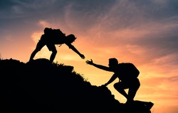 People helping each other up a mountain. Helping hand and teamwork concept. 