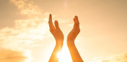 Feelings of hope, empowerment belief, and spiritual light. Hand up to the sunshine sunrise sky. 