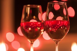 Two glasses of red wine in a romantic candle light dinner setting. 