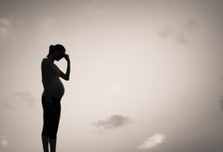 Silhouette of sad pregnant woman. Pregnancy difficulties concept. 