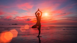 Meditation girl on the sea during sunset. Yoga silhouette. Fitness and healthy lifestyle. 