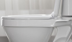 Part of white toilet bowl close-up.