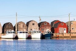 A line of Oyster barns and fishing boats at Malpeque Harbour on the north shore of Prince Edward Island (PEI) , Canada