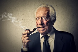 senior businessman smokes a pipe