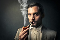 elegant young man smokes a pipe