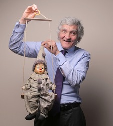 senior businessman with marionette in his hands