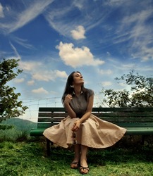 young woman sitting on a bench in a park