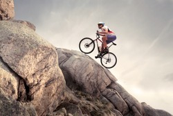 Cyclist climbing on a rock
