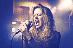 Beautiful woman singing into the microphone
