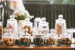 Details of a tasty candy bar with jugs of sweets, cookies and marshmallows