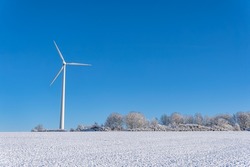 Wind Turbine in a Winter Landscape. Clear blue sky.