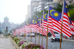 The Malaysia flag is also known as Jalur Gemilang waving with a city in the background. Independence Day or Merdeka Day celebration on 31 August and Hari Malaysia on 16 September, copy space concept.