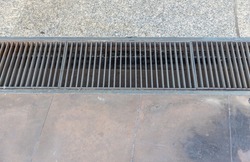Grille drain of sewer around the street or walkway . Water recirculation system. Wastewater treatment. Grille of the drainage system on the pedestrian sidewalk.